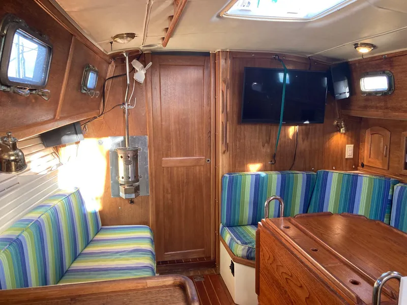 Slide: The Image of Interior of 1992 Pacific Seacraft 37 Cutter with striped seating and wooden finishes. - 10