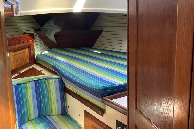 Slide: The Image of Cozy cabin interior of 1992 Pacific Seacraft 37 Cutter with striped bedding. - 14