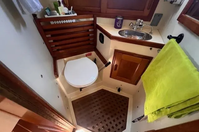 Slide: The Image of 1992 Pacific Seacraft 37 Cutter bathroom with wooden accents and compact design. - 17
