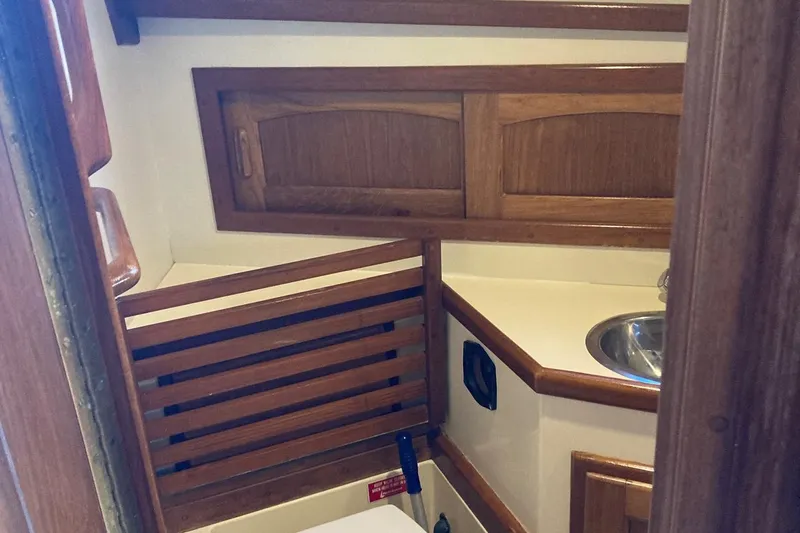 Slide: The Image of Interior of 1992 Pacific Seacraft 37 Cutter, featuring wooden cabinetry and compact sink. - 18