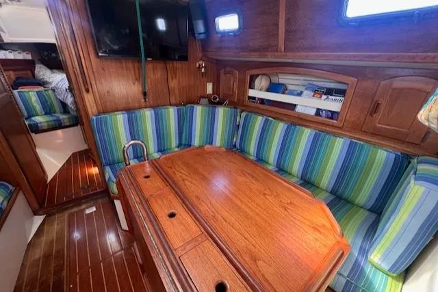 Slide: The Image of Interior of 1992 Pacific Seacraft 37 Cutter with striped seating and wooden table. - 3