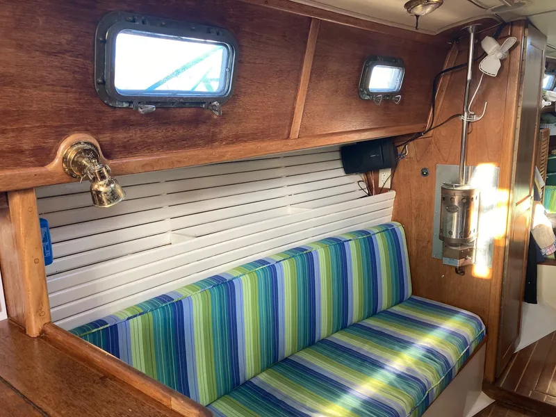 Slide: The Image of Interior of 1992 Pacific Seacraft 37 Cutter with striped seating and wooden accents. - 4