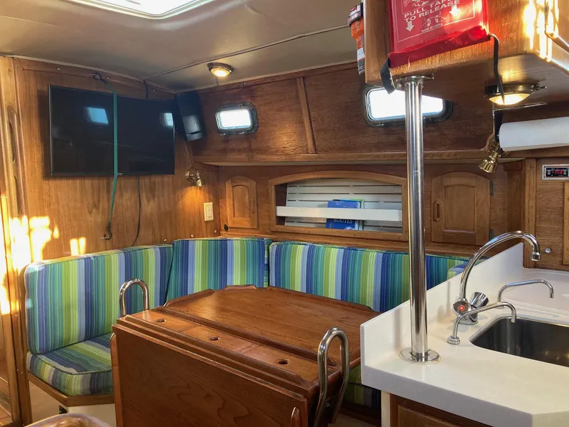 Slide: The Image of Interior of 1992 Pacific Seacraft 37 Cutter with striped seating and wooden cabinetry. - 5