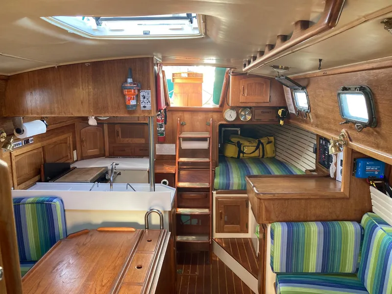 Slide: The Image of Interior of 1992 Pacific Seacraft 37 Cutter sailboat with wood finish and striped seating. - 6