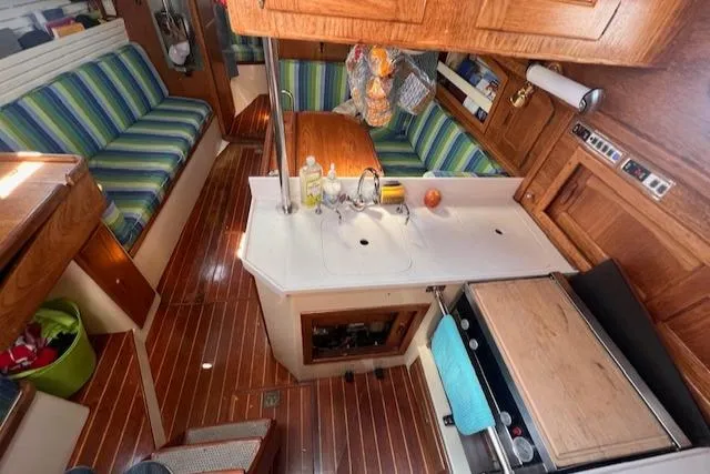 Slide: The Image of Interior of 1992 Pacific Seacraft 37 Cutter with striped seating and wooden cabinetry. - 9