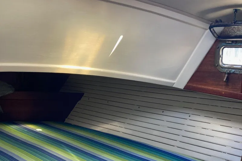 Slide: The Image of Interior of 1992 Pacific Seacraft 37 Cutter with striped bedding and wooden paneling. - 15
