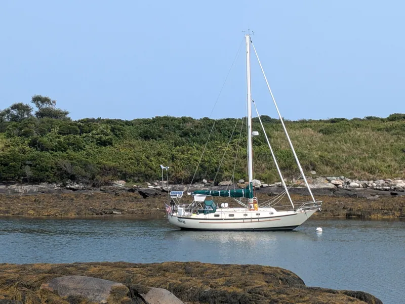 Slide: The Image of 1992 Pacific Seacraft 37 Cutter sailboat anchored in a serene coastal inlet. - 42