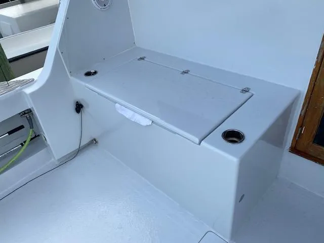 Slide: The Image of 1985 Bertram 38 Convertible boat interior with storage compartment and cup holders. - 10