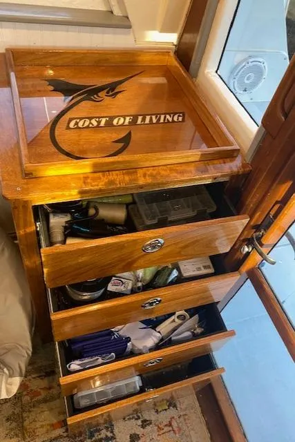 Slide: The Image of Wooden storage drawers on 1985 Bertram 38 Convertible boat, labeled "Cost of Living." - 30