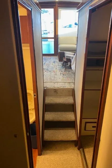 Slide: The Image of Interior view of 1985 Bertram 38 Convertible yacht with carpeted stairs and wooden paneling. - 34