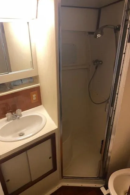 Slide: The Image of 1985 Bertram 38 Convertible bathroom with shower, sink, and storage cabinets. - 35