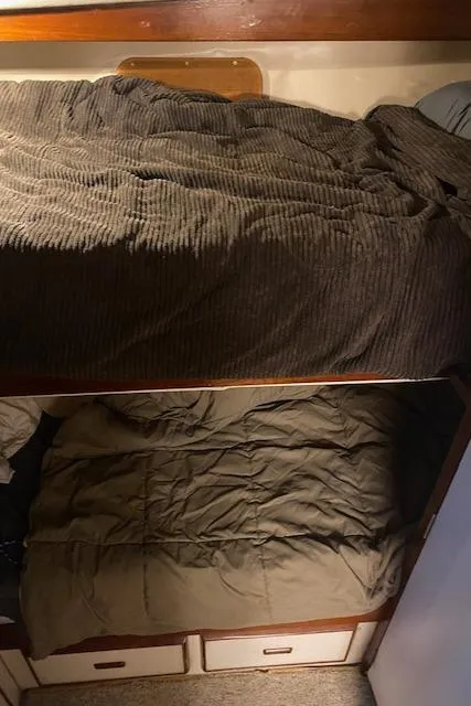 Slide: The Image of Bunk beds in a 1985 Bertram 38 Convertible boat cabin, featuring cozy bedding. - 36