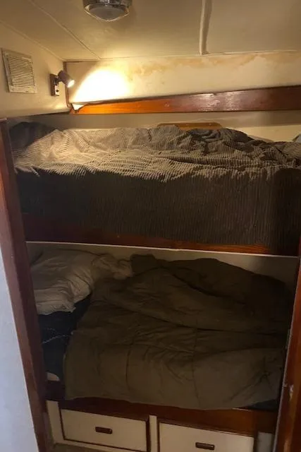 Slide: The Image of 1985 Bertram 38 Convertible cabin with cozy bunk beds and storage drawers. - 37