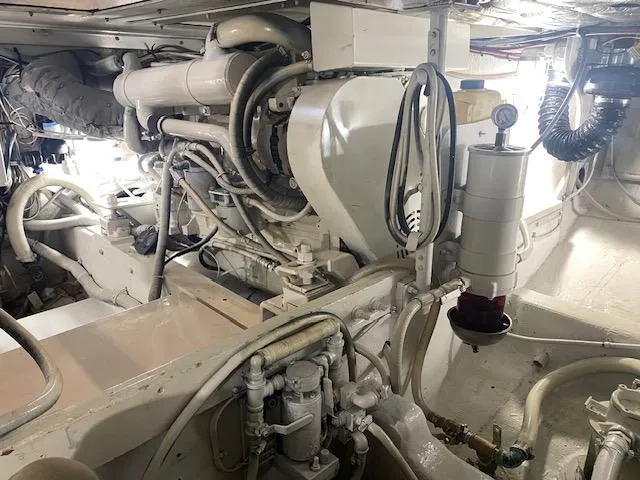 Slide: The Image of Engine room of 1985 Bertram 38 Convertible boat, showcasing mechanical components and piping. - 47