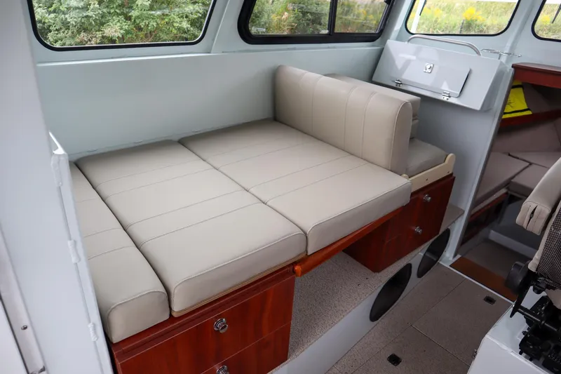 Slide: The Image of 2024 Hewescraft 270 Pacific Explorer interior with beige seating and storage compartments. - 11