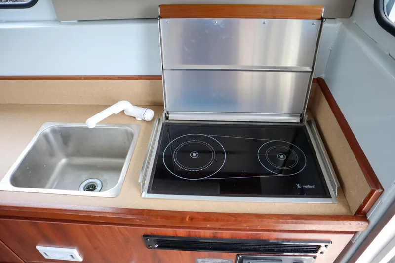 Slide: The Image of 2024 Hewescraft 270 Pacific Explorer kitchen with sink and electric stove. - 12