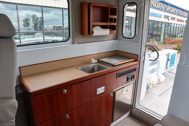 Slide: The Image of 2024 Hewescraft 270 Pacific Explorer interior with kitchenette and sink. - 13