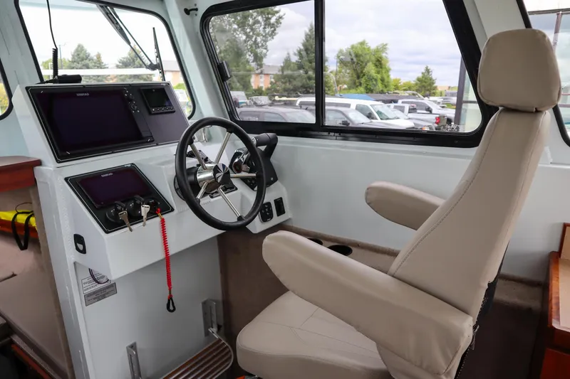 Slide: The Image of 2024 Hewescraft 270 Pacific Explorer helm with modern controls and comfortable seating. - 14