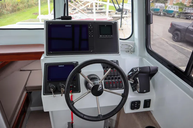 Slide: The Image of 2024 Hewescraft 270 Pacific Explorer helm with modern navigation equipment and steering wheel. - 15