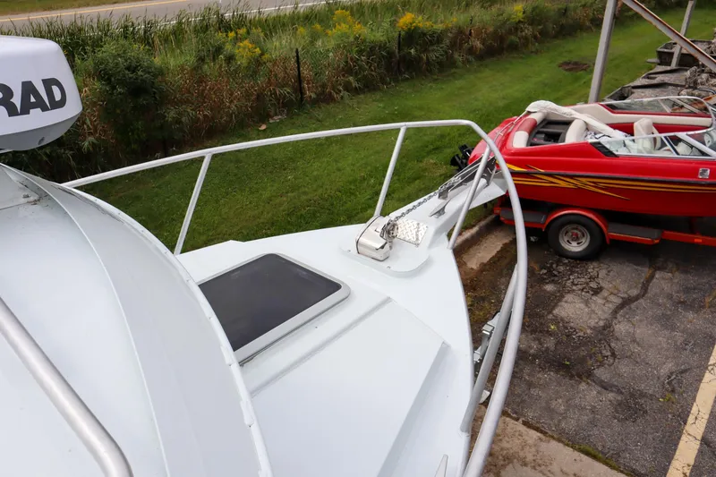 Slide: The Image of 2024 Hewescraft 270 Pacific Explorer boat parked near a red speedboat. - 16
