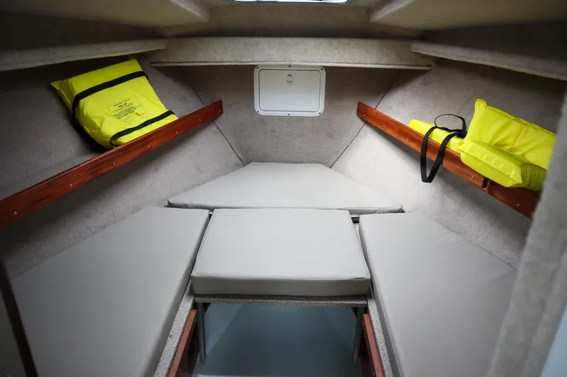 Slide: The Image of 2024 Hewescraft 270 Pacific Explorer cabin interior with life jackets and cushioned seating. - 17