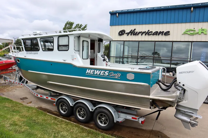 Slide: The Image of 2024 Hewescraft 270 Pacific Explorer boat on trailer outside dealership. - 2