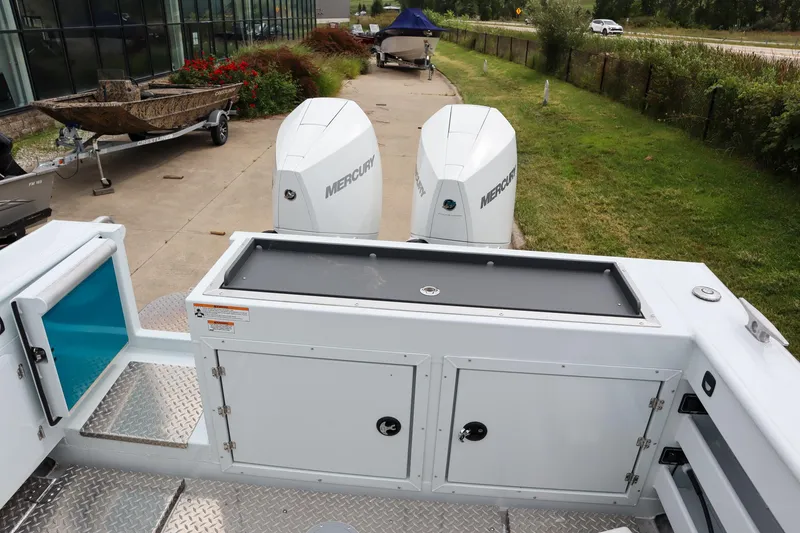 Slide: The Image of 2024 Hewescraft 270 Pacific Explorer with dual Mercury engines, docked outdoors. - 5