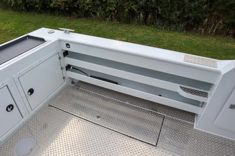 Slide: The Image of 2024 Hewescraft 270 Pacific Explorer deck with storage compartments and non-slip flooring. - 7