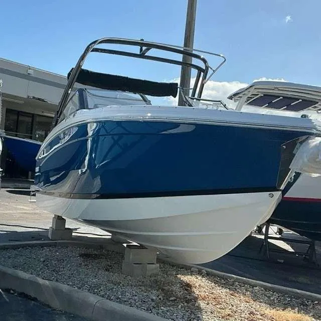 Slide: The Image of 2025 Cobalt R8 boat in blue and white, displayed outdoors on a sunny day. - 1