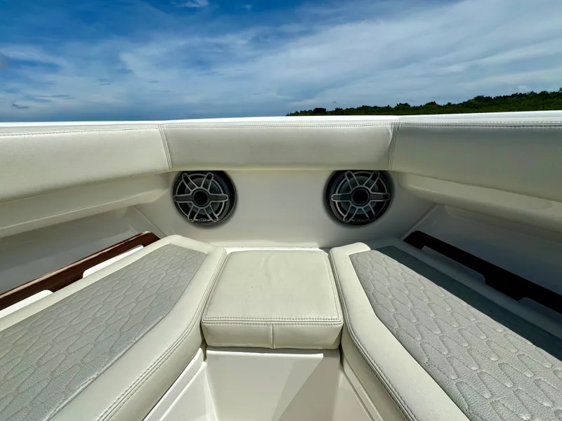 Slide: The Image of Luxurious seating on 2020 Solace 345 boat with built-in speakers, under a clear blue sky. - 29