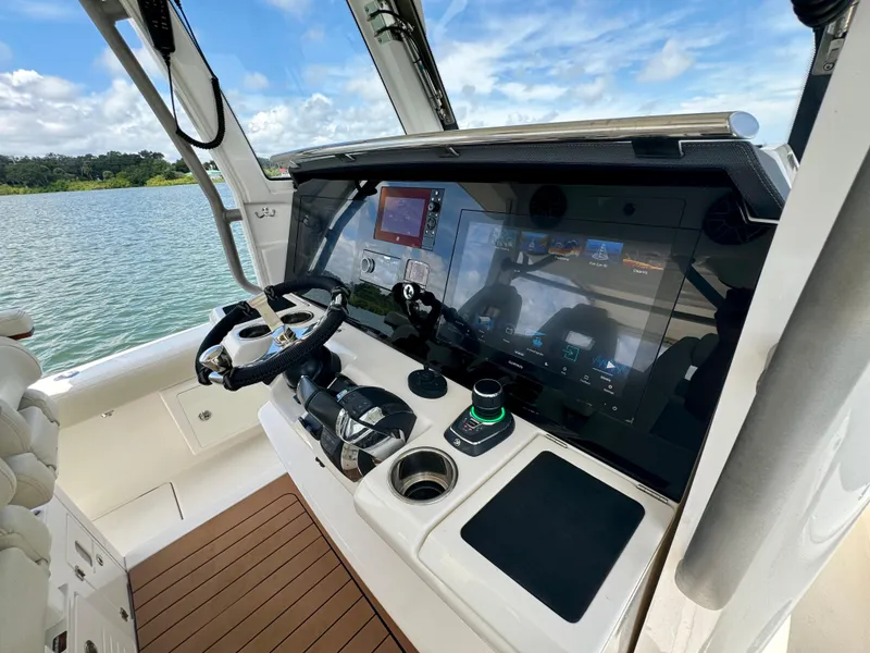 Slide: The Image of Solace 345 boat helm with advanced navigation system, 2020 model, on a scenic lake. - 39