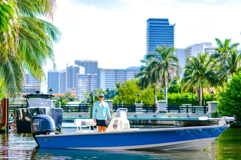 The Image of 2022 Hewes Redfisher 21 boat on water, city skyline and palm trees in background. - 1