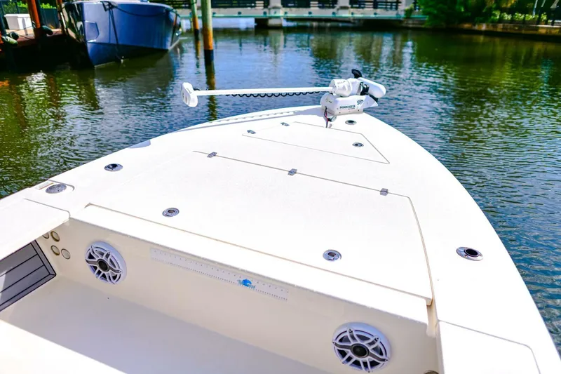 Slide: The Image of 2022 Hewes Redfisher 21 boat deck with trolling motor on calm water. - 13