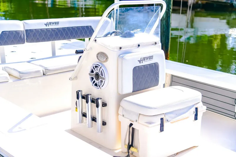 Slide: The Image of 2022 Hewes Redfisher 21 boat interior with seating and console, docked by the water. - 14