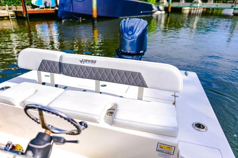 Slide: The Image of 2022 Hewes Redfisher 21 boat interior with white seating and steering wheel. - 19