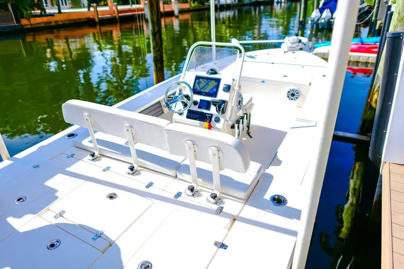 Slide: The Image of 2022 Hewes Redfisher 21 boat docked, featuring a sleek console and spacious deck. - 22