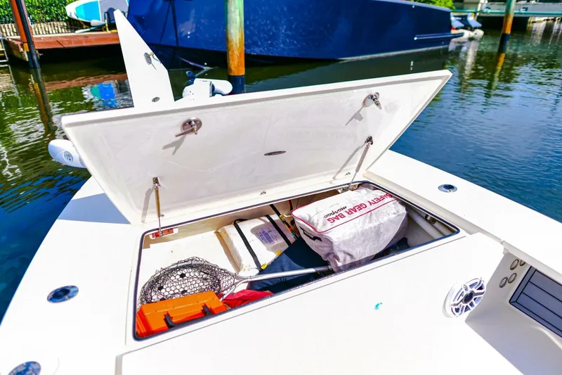 Slide: The Image of 2022 Hewes Redfisher 21 boat storage compartment with fishing gear and safety equipment. - 25