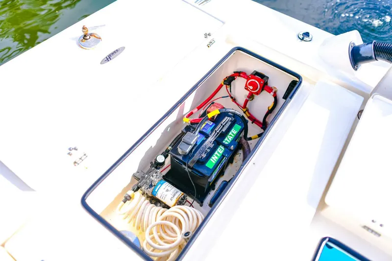 Slide: The Image of 2022 Hewes Redfisher 21 boat battery compartment with wiring and equipment. - 26