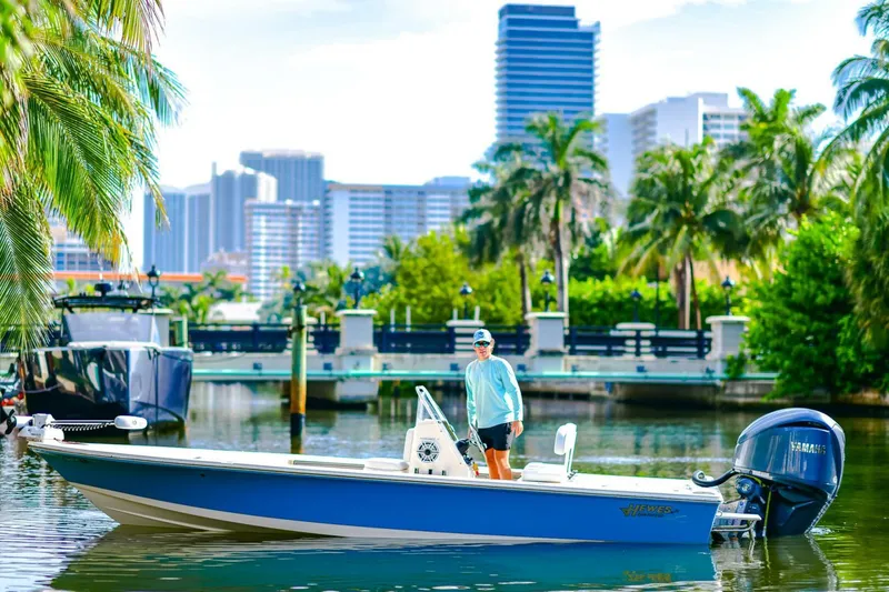 Slide: The Image of 2022 Hewes Redfisher 21 boat on a scenic waterway with city skyline and palm trees. - 3