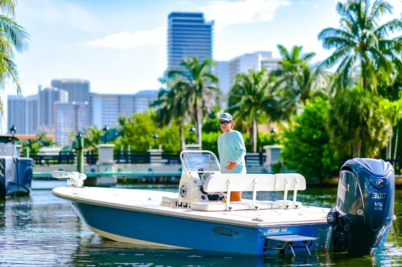 Slide: The Image of 2022 Hewes Redfisher 21 boat on water, city skyline and palm trees in background. - 5