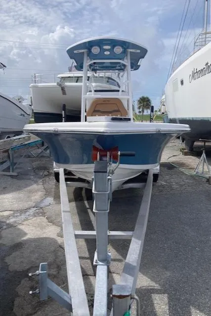 Slide: The Image of 2025 Sea Pro 250 DLX boat on trailer, docked in a marina. - 2