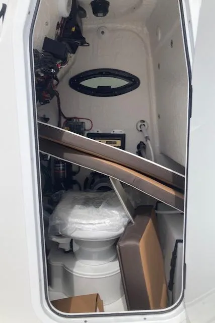 Slide: The Image of Interior of 2025 Sea Pro 250 DLX boat cabin with toilet and storage. - 6