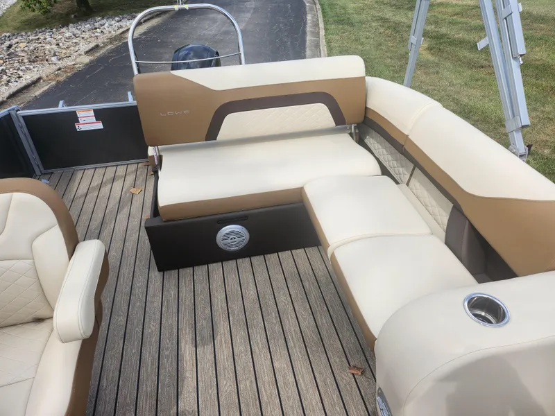Slide: The Image of 2022 Lowe SS 210 CL boat interior with beige seating and wood-style flooring. - 13