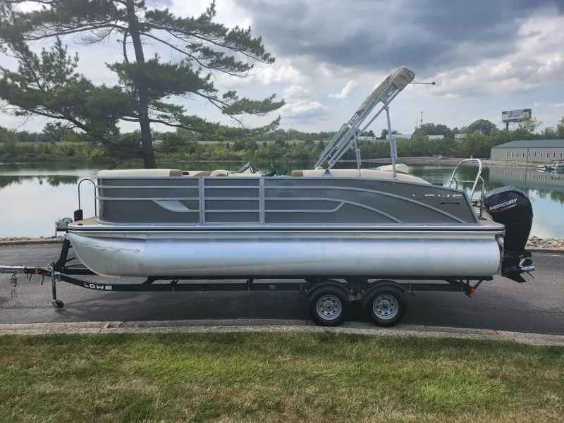 Slide: The Image of 2022 Lowe SS 210 CL pontoon boat on trailer by a lake. - 9