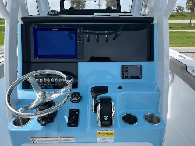 Slide: The Image of 2025 Sea Pro 242 DLX boat console with steering wheel and navigation system. - 8