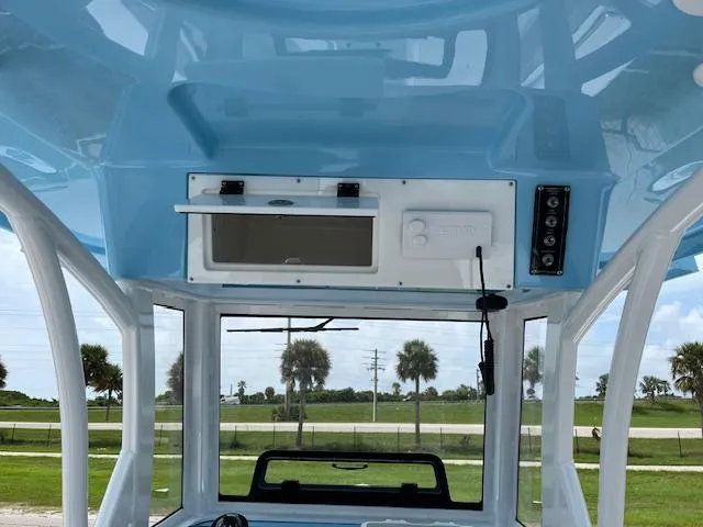 Slide: The Image of 2025 Sea Pro 242 DLX boat interior with blue ceiling and control panel. - 9