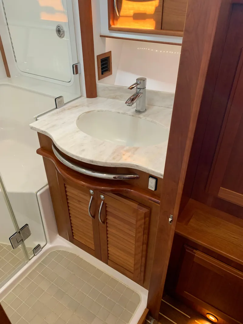Slide: The Image of 2014 Sabre 48 Salon Express bathroom with wooden cabinetry and marble countertop. - 11