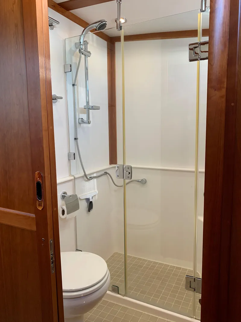 Slide: The Image of 2014 Sabre 48 Salon Express bathroom with glass shower, wooden door, and modern fixtures. - 12