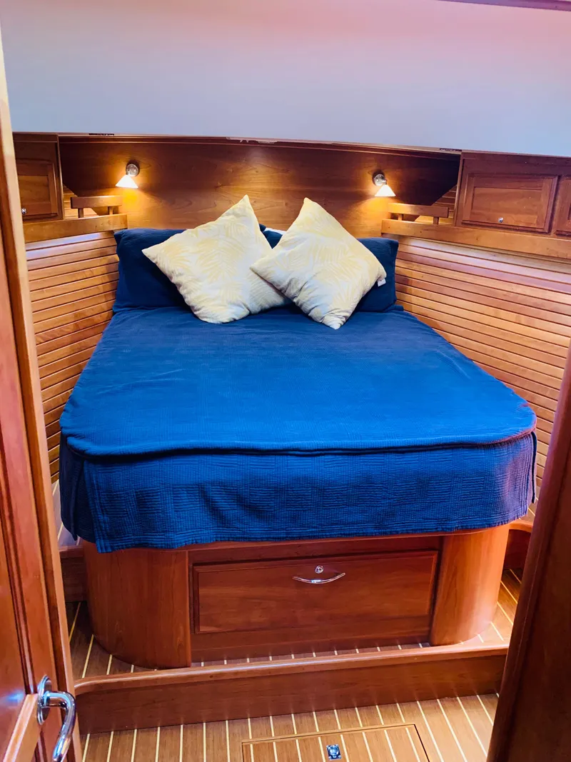 Slide: The Image of Cozy cabin interior of 2014 Sabre 48 Salon Express with wooden accents and plush bedding. - 13