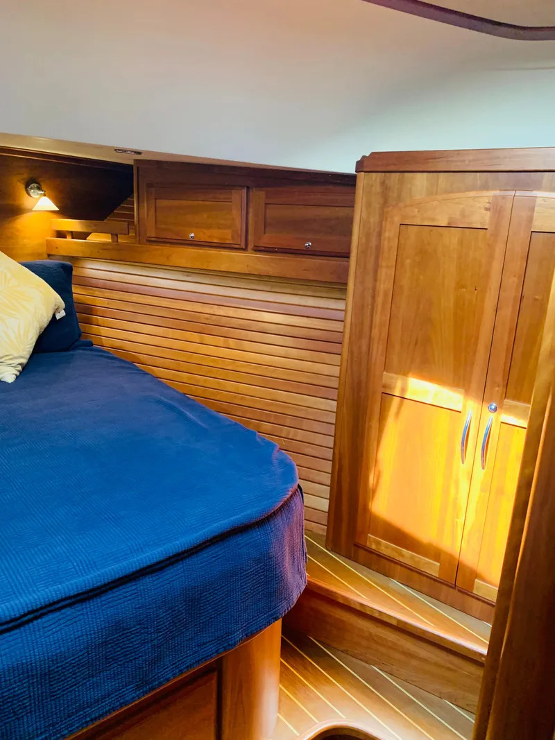 Slide: The Image of 2014 Sabre 48 Salon Express cabin with wooden interior and blue bedding. - 15